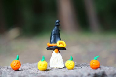 Şenlikli şapkalı bir cüce figürü. Yakında balkabağı figürleri var..