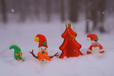 Kış ormanındaki peri masalı karakterleri. Kardan adam, Noel Baba ve cüce.