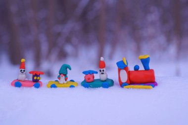 Kar beyazı arka planında plastik oyuncaklar olan Noel treni..