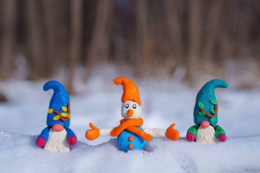 Kardan adam ve karlı ormanda bir cüce figürü. Yeni yıl havası..