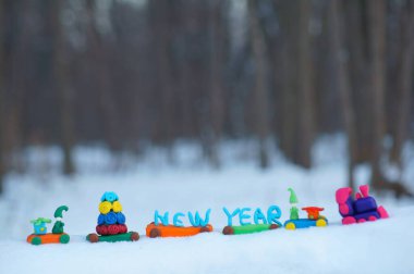Oyuncak tren, kış ormanında plastikten yapılmış Noel oyuncaklarıyla dolu. Tatil dekorasyonları.