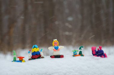 Kar yağışının arka planında Noel oyuncakları olan oyuncak tren..