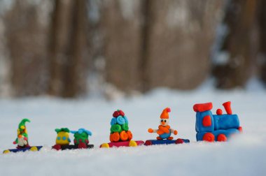 Ormanda karların arkasında plastikten yapılmış Noel treni..