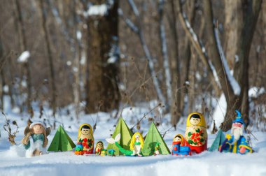 Karlı bir ormanda peri masalı karakterleri. Matrioshka, büyücü, deniz kızı, melek, kağıt Noel ağacı ve cüce..
