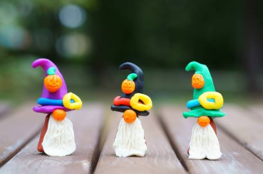 Bir şenlik şapkası ve balkabağıyla süslenmiş plastikten yapılmış üç cüce figürü. Cadılar Bayramı konsepti.