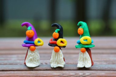 Bir şenlik şapkası ve balkabağıyla süslenmiş plastikten yapılmış üç cüce figürü. Cadılar Bayramı konsepti.