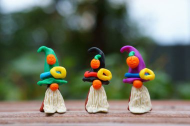 Bir şenlik şapkası ve balkabağıyla süslenmiş plastikten yapılmış üç cüce figürü. Cadılar Bayramı konsepti.