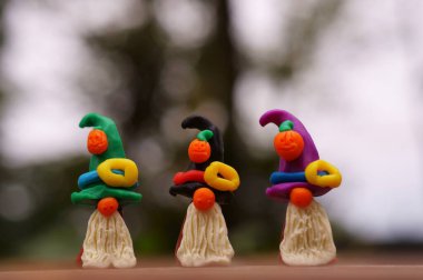 Bir şenlik şapkası ve balkabağıyla süslenmiş plastikten yapılmış üç cüce figürü. Cadılar Bayramı konsepti.