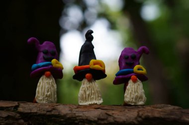 Karanlık bir arka planda üç cüce figürü.