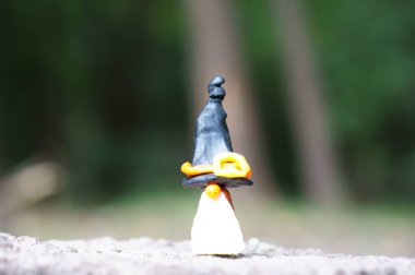 Şenlik şapkası içindeki plastik bir cücenin figürü. Cadılar Bayramı konsepti.