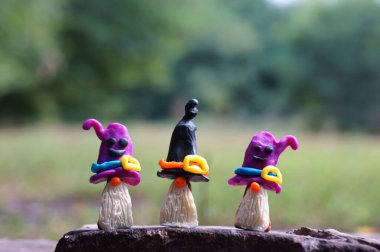 Plastikten yapılmış üç peri masalı cücesinin figürleri. Cadılar Bayramı konsepti.