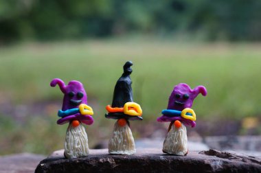 Plastikten yapılmış üç peri masalı cücesinin figürleri. Cadılar Bayramı konsepti.