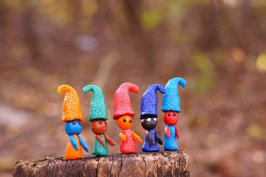 Renkli arkaplanda çok renkli cücelerin figürleri.