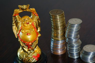 Masanın üzerinde Altın Buda figürü var. Yanında bir yığın bozuk para var. Zenginlik ve refahın sembolü.
