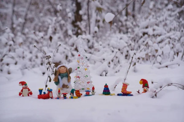 Plastikten yapılmış bir Noel treni ve karlı bir ormanda bir melek figürü..