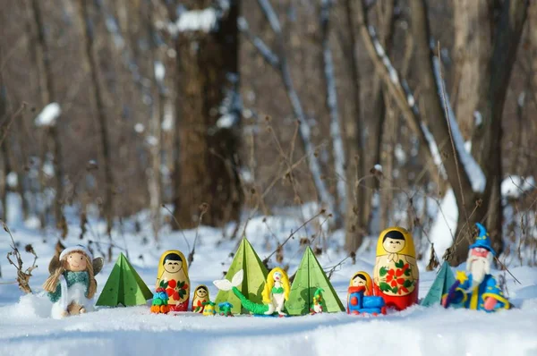 Karlı bir ormanda peri masalı karakterleri. Matrioshka, büyücü, deniz kızı, melek, kağıt Noel ağacı ve cüce..