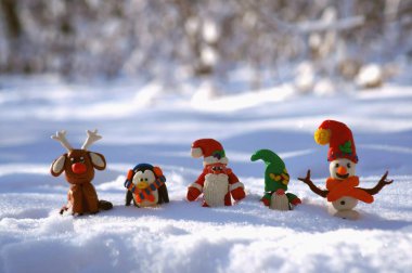Kardan adam, Noel Baba, geyik, cüce ve karlı bir ormanda penguen figürleri. Muhteşem yeni yıl karakterleri.