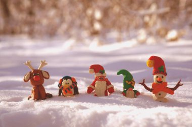 Kardan adam, Noel Baba, geyik, cüce ve karlı bir ormanda penguen figürleri. Muhteşem yeni yıl karakterleri.