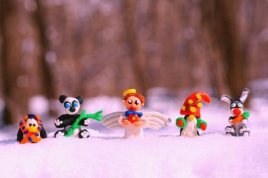 Kış ormanındaki peri masalı karakterlerinin figürleri. Yetenekli bir melek, cüce, havuçlu bir tavşan, bir panda, eşarplı bir penguen..