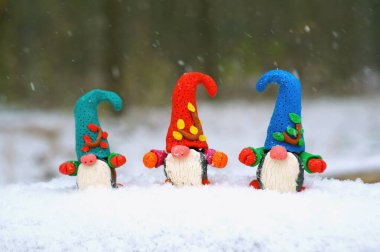 Karlı bir ormanda çok renkli cücelerin figürleri. Masal karakterleri.