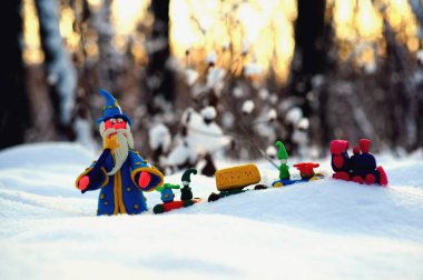 Kış ormanındaki bir büyücü figürü. Noel oyuncak treninin yanında..