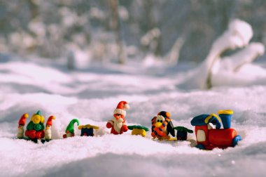 Kış ormanında peri masalı karakterleri ve hediyeleri olan oyuncak tren. Cüce, Noel Baba, penguen ve kardan adam.