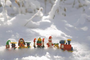 Kış ormanında peri masalı karakterleri ve hediyeleri olan oyuncak tren. Cüce, Noel Baba, penguen ve kardan adam.
