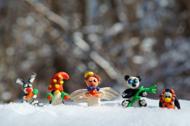 Kış ormanındaki peri masalı karakterlerinin figürleri. Yetenekli bir melek, cüce, havuçlu bir tavşan, bir panda, eşarplı bir penguen..