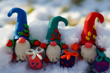 Karlı bir ormanda üç peri cücesi.