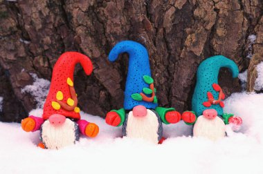 Karlı bir ormanda çok renkli cücelerin figürleri. Masal karakterleri.