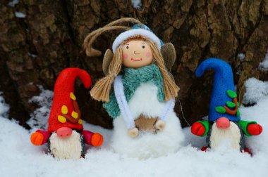 Karlı bir ormanda Noel heykelcikleri. Cüceler, bir kardan adam ve bir melek.