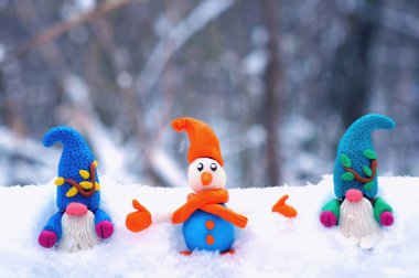 Kardan adam ve karlı ormanda bir cüce figürü. Yeni yıl havası..