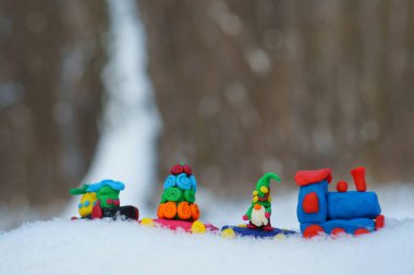 Ormanda karların arkasında plastikten yapılmış Noel treni..