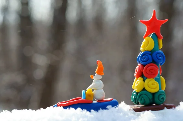 Egy Plasztikából Készült Hójárón Lévő Játék Hóember Egy Karácsonyfát Hordoz — Stock Fotó