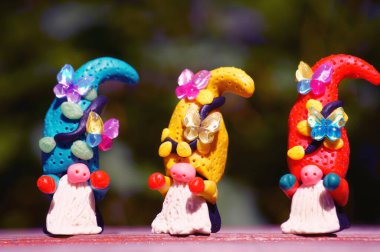 Oyuncak kelebeklerle süslenmiş plastikten yapılmış üç muhteşem cüce. Yakın plan. Noel süslemeleri.