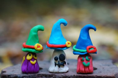 Renkli arka planda üç hayaletin figürleri. Cadılar Bayramı süslemeleri. Komik hayaletler.