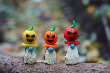 Renkli balkabaklarıyla süslenmiş plastikten yapılmış üç muhteşem cüce. Cadılar Bayramı konsepti.