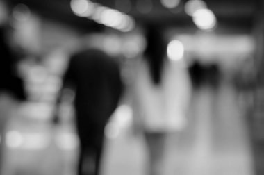 Arka plan bulanık. Alışveriş merkezindeki insanların siluetleri. Siyah beyaz fotoğraf.