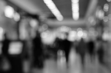 Arka plan bulanık. Alışveriş merkezindeki insanların siluetleri. Siyah beyaz fotoğraf.