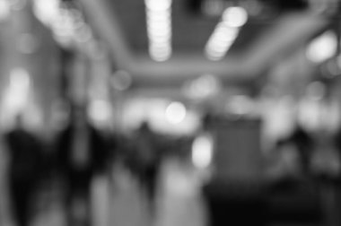 Arka plan bulanık. Alışveriş merkezindeki insanların siluetleri. Siyah beyaz fotoğraf.