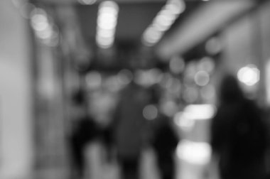 Arka plan bulanık. Alışveriş merkezindeki insanların siluetleri. Siyah beyaz fotoğraf.