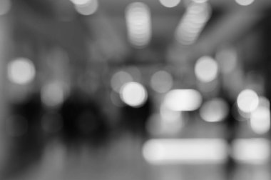 Arka plan bulanık. Alışveriş merkezindeki insanların siluetleri. Siyah beyaz fotoğraf.