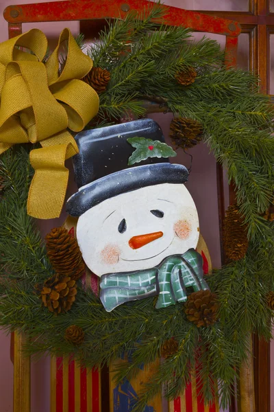 Kerstmis sneeuwpop met krans en lint — Stockfoto