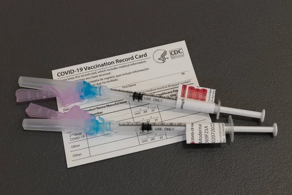インディアナポリス Circa 2021年11月 Covid 19予防接種ブースター注射器または低血圧の針と予防接種記録カード すべての大人のためのCovid 19ブースターが推奨されました — ストック写真