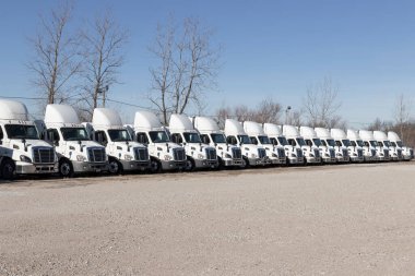 Indianapolis - Circa January 2022: Freightliner Semi Tractor Trailer Trucks Lined up for sale. Freightliner is owned by Daimler. clipart