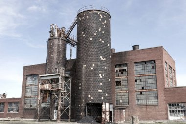 Terk edilmiş kömür santrali, kırık camları, fazla kömürü ve yıpranmış dış görünüşü. Kömür santralleri yenilenebilir enerji kaynakları lehine kademeli olarak kapatıldı.