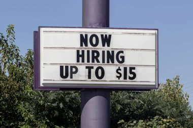 Now Hiring Up to $15 an hour sign. Amid a shortage of workers, companies and restaurants are increasing wages to attract applicants.