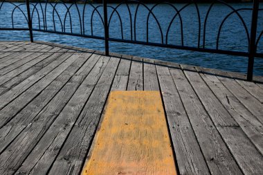 Tahta güverte, gölün kenarındaki metal korkuluklarla korunuyor. 