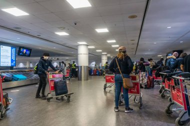 Gelen havayolu yolcuları, Lester Pearson Havaalanı, Toronto, Kanada 'da bagajlarını bekliyor. 