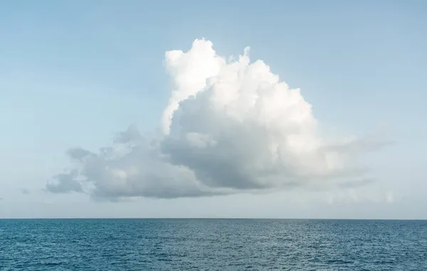 Ett stort vitt moln i blå himmel över havslandskapet. Moln över havet vatten panorama, horisont, vacker tropisk karibisk sommardag havsutsikt, molnigt väder med kopieringsutrymme — Stockfoto